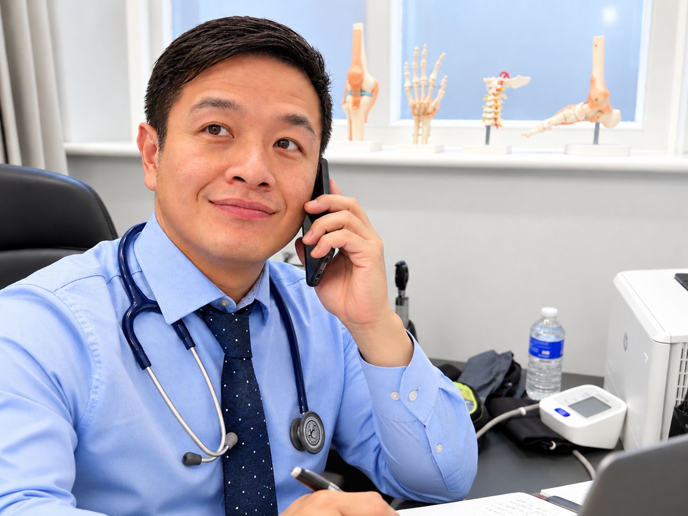 Doctor in a consulting room speaking on the phone