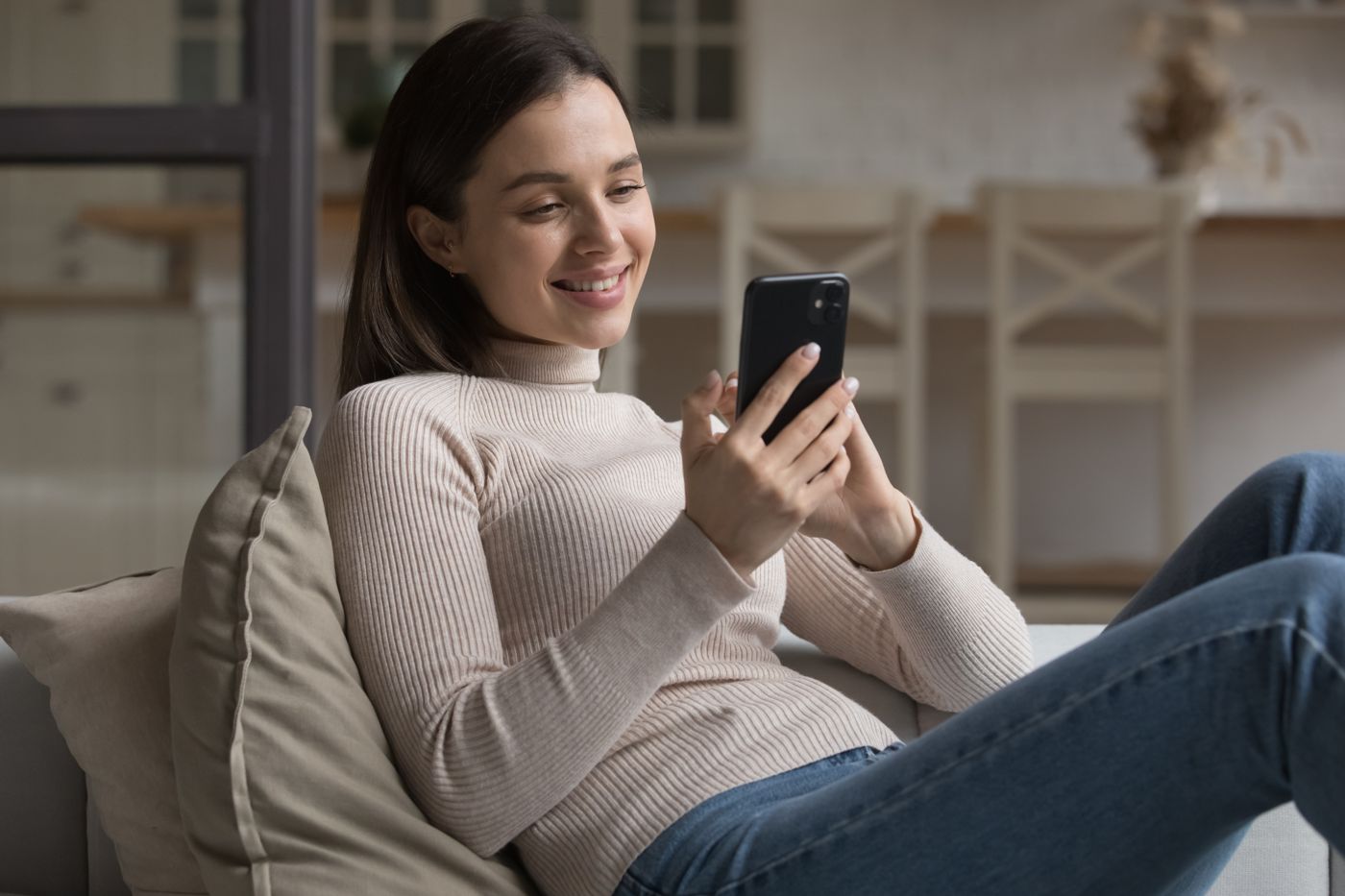 Woman relaxing on a sofa and ordering on her phone